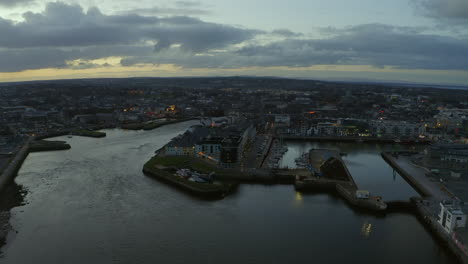 aerial dolly shot descending and focusing on galway harbor at twilight