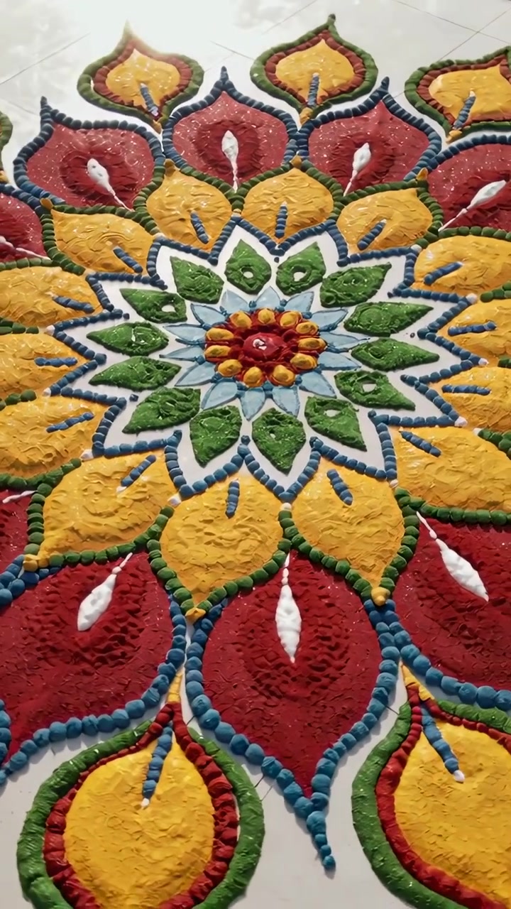 Video verticale: Panoramica della telecamera che rivela un rangoli su piastrelle bianche a casa, con punti blu e un centro dorato.