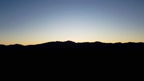 Mountain-silhouetted-on-horizon-at-blue-hour
