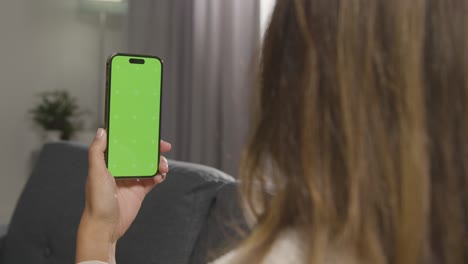 Over-The-Shoulder-Shot-Of-Woman-Using-Green-Screen-Mobile-Phone-2