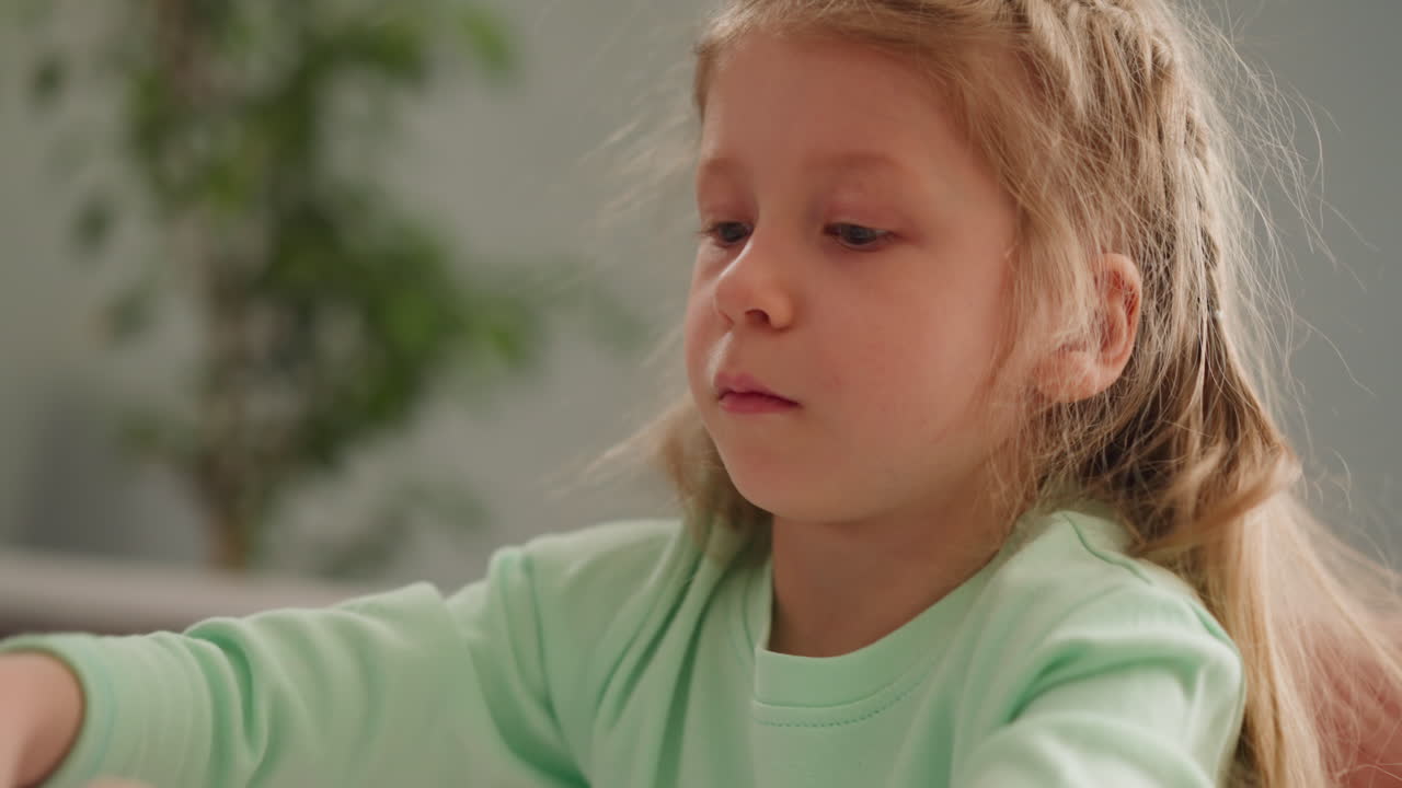 Una bambina picchietta il pennello per far cadere la pittura durante una lezione di Ebru.