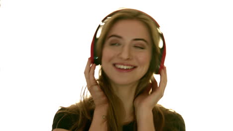 una dama se ve alegre siguiendo el ritmo en sus auriculares