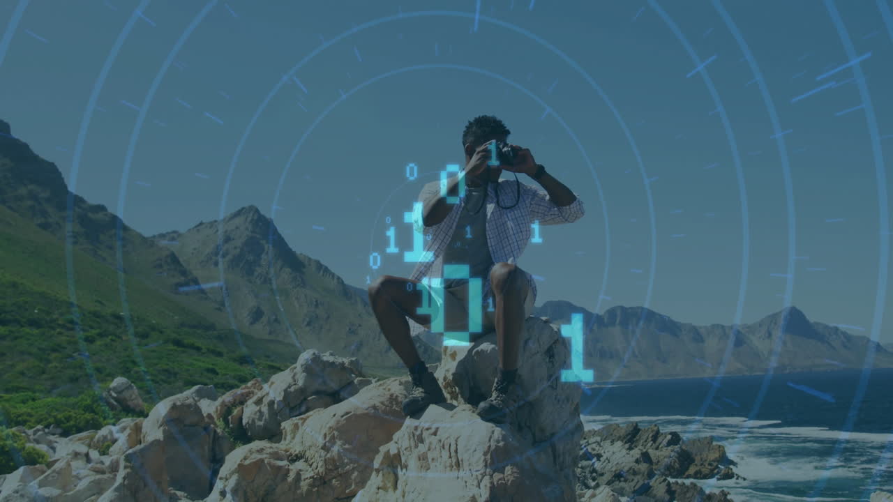 Animation of binary codes, circles over african american man looking through binoculars at outdoor