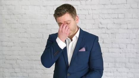 un hombre de negocios cansado quitándose las gafas y frotándose los ojos y la nariz