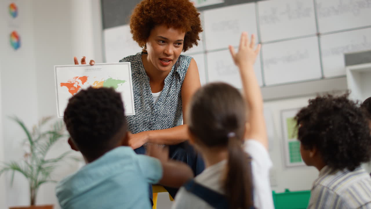 alumnos de escuelas primarias multiculturales con maestras haciendo preguntas en la clase de geografía