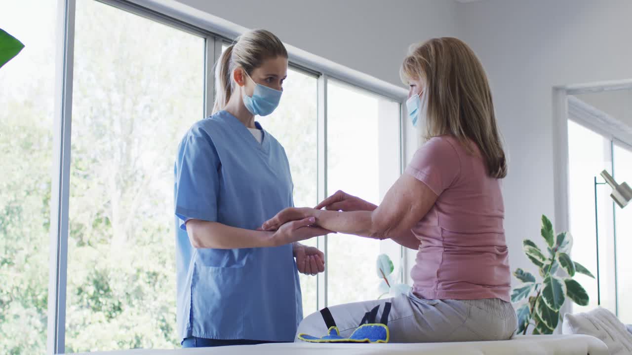 Operatrice sanitaria che allunga il polso di una donna anziana a casa