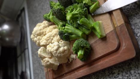 Verduras-Orgánicas-Con-Coliflor-Fresca-Y-Brócoli-Picado-En-Tablero-De-Madera