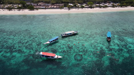 Touristen-Schwimmen-Im-Kristallklaren-Blauen-Wasser-Mit-Booten-In-Bali,-Indonesien