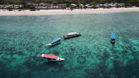 los turistas nadan en aguas cristalinas con botes en bali, indonesia