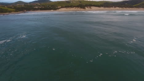 Cinematic-flying-of-surfers-surfing-along-coast-of-East-London-South-Africa-aerial