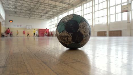 volleyball ball, with players training in the background