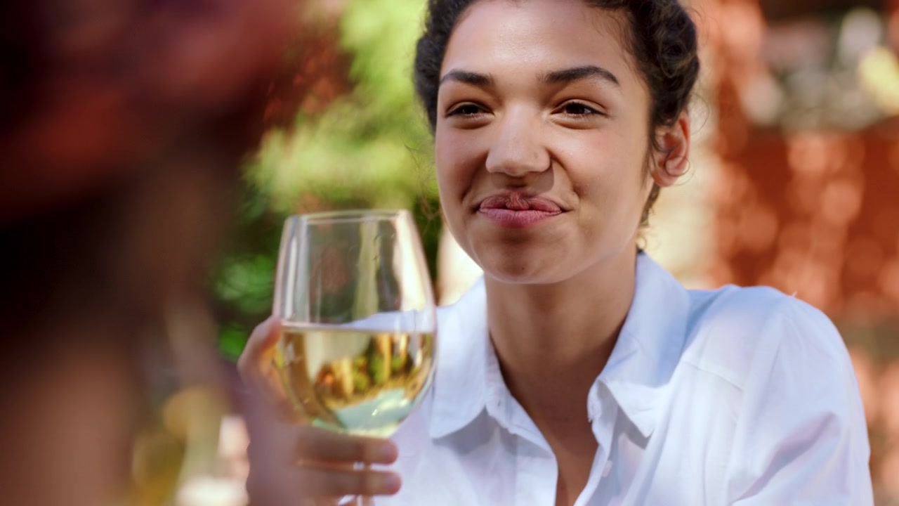 Young Woman Laughing and Drinking White Wine Outdoors