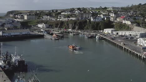 pintoresco puerto este irlandés de dunmore con un barco de guardacostas naranja