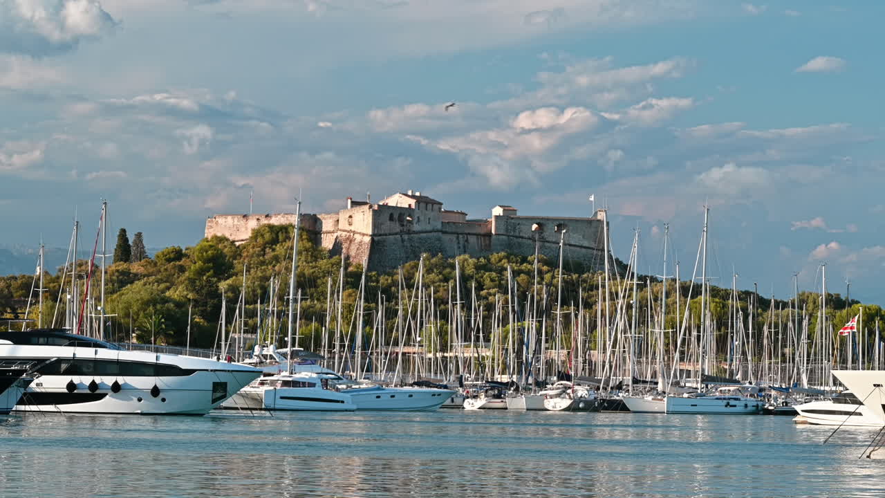 Vista del porto marittimo di Antibes, Francia. Barche e yacht ormeggiati, Fort Carre sullo sfondo, vegetazione