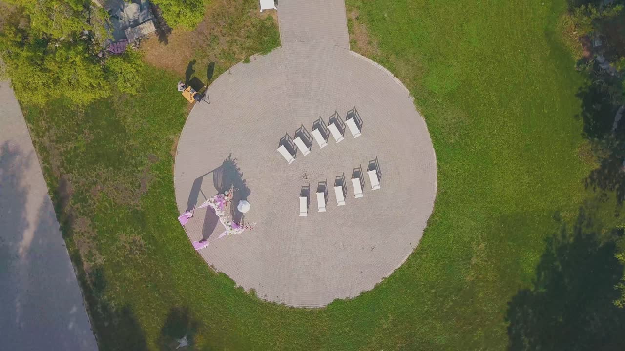 камера поднимается над местом проведения свадьбы в парке в солнечный день