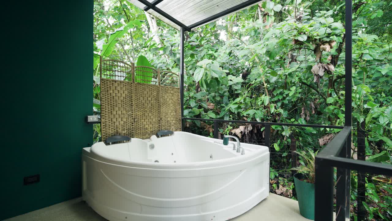 Outdoor hot tub surrounded by lush tropical foliage