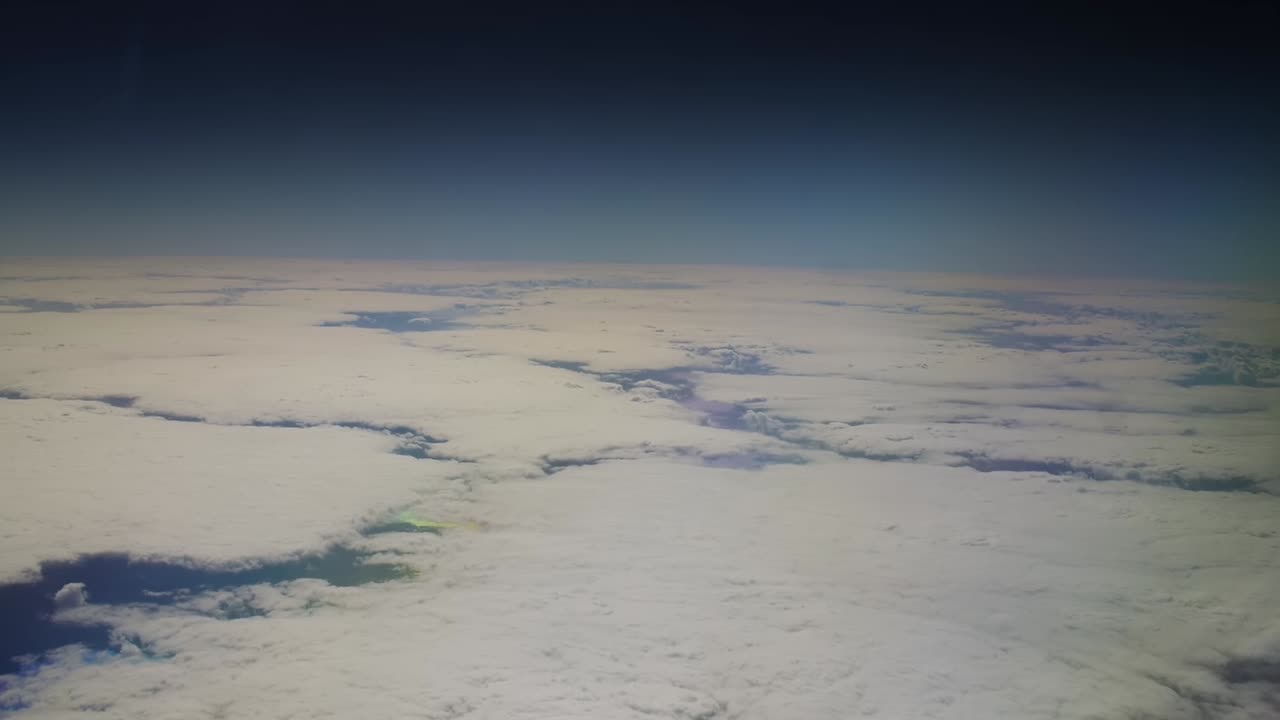 Big white clouds over the atlantic ocean with black space over the curvature of the earth
