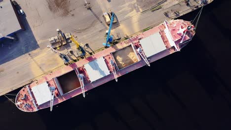 bird's-eye view of grain terminal operations with ship docked at concrete quay