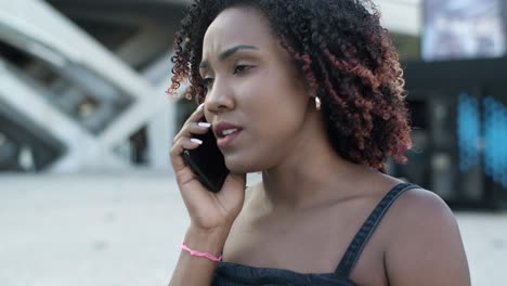 vista de cerca de una mujer sonriente hablando en un teléfono inteligente