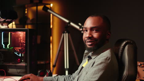 portrait of smiling man playing fps videogame on pc screen