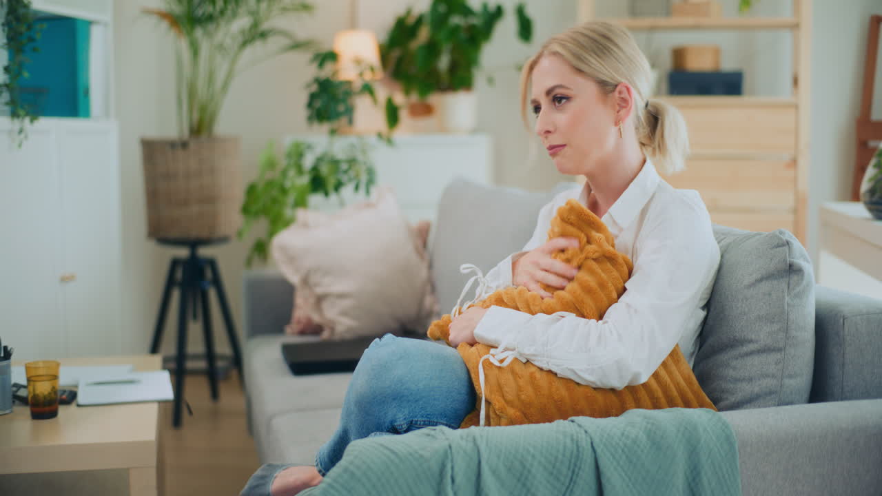 печальная разбитая девушка обнимает подушку