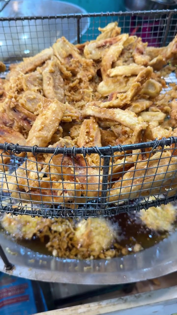 Frittelle di banana fritte che scolano in un cestello di metallo