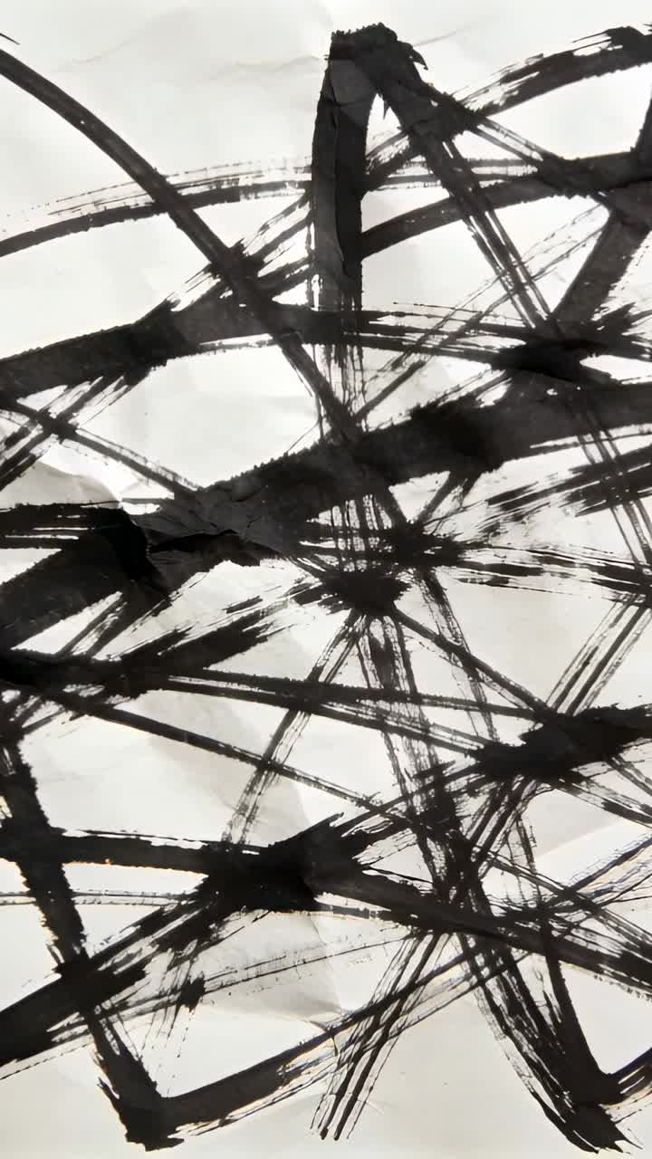 Vertical video: Moving camera revealing crumpled sheet with black brush marks to show tear on table