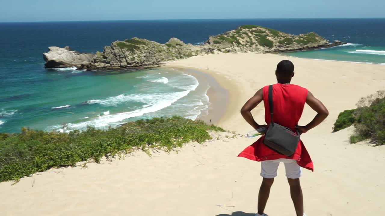 Young guy looking out at Robberg Beach, Plettenberg bay