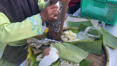 el proceso de raspar coco para una deliciosa cubierta de pastel de lupis