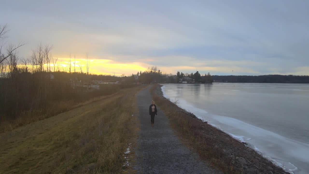 беспилотный летательный аппарат следит за молодой женщиной в зимний день