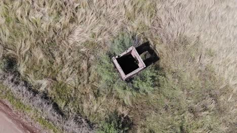 aerial drone shot of an abandoned guard house in a field