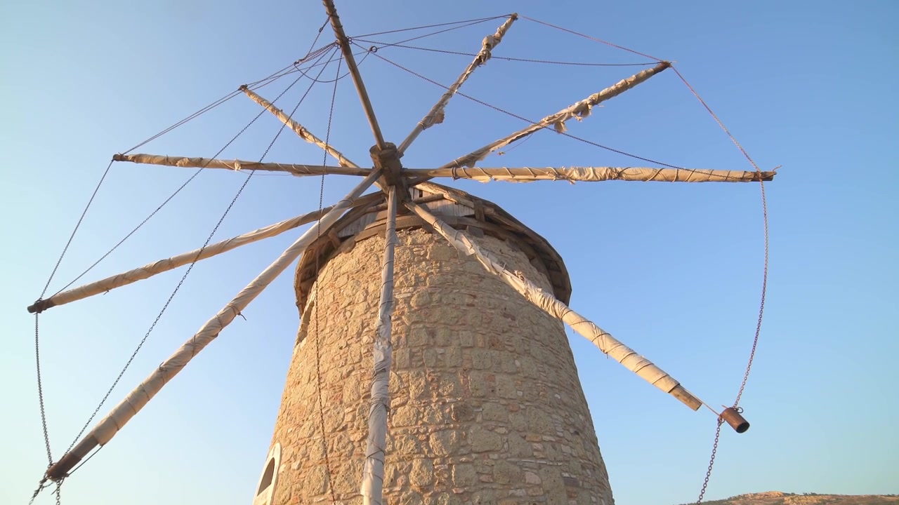 Moinho de Vento Tradicional de Pedra em uma Encosta ao Pôr do Sol