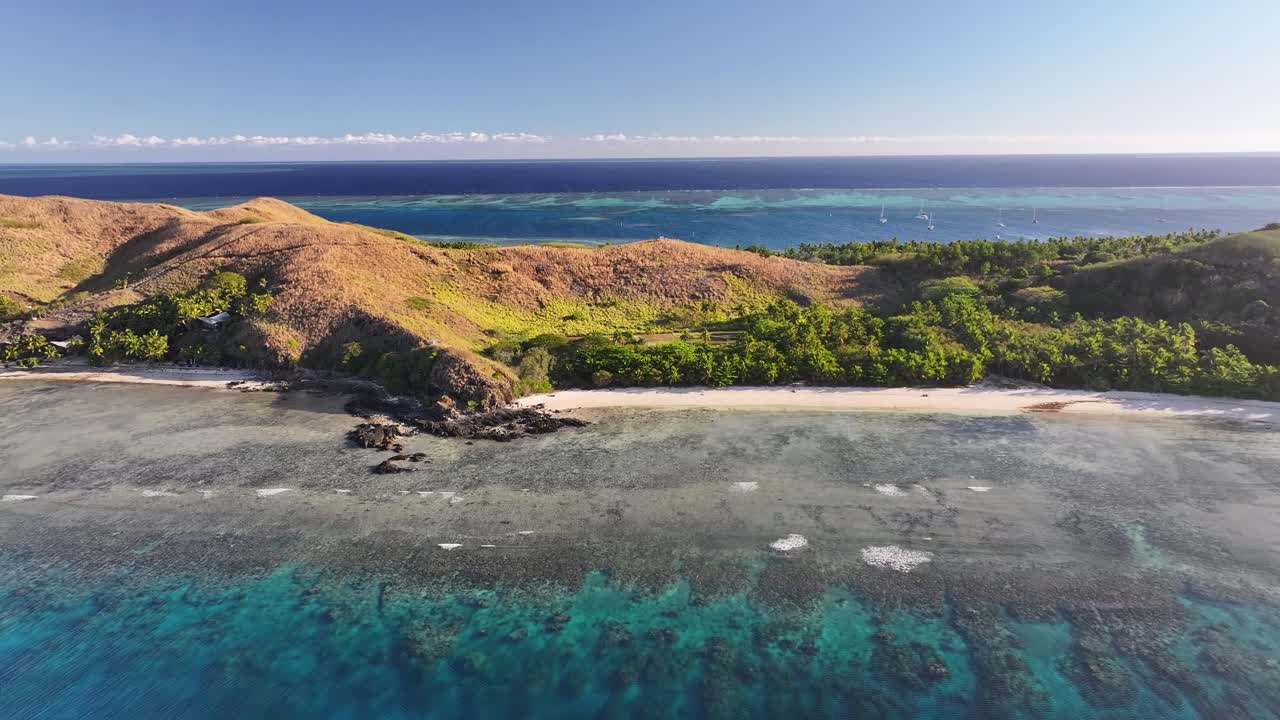 Picturesque sandy beach and lush green covered small island in Fiji, Mana Island. Aerial drone