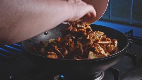 adding chopped fried chicken breast into the pan with white onion and bell peppers cooking