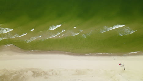 tourist enjoying the beautiful waves washing up on the beachfront at baltic sea in osetnik, poland during sunny day