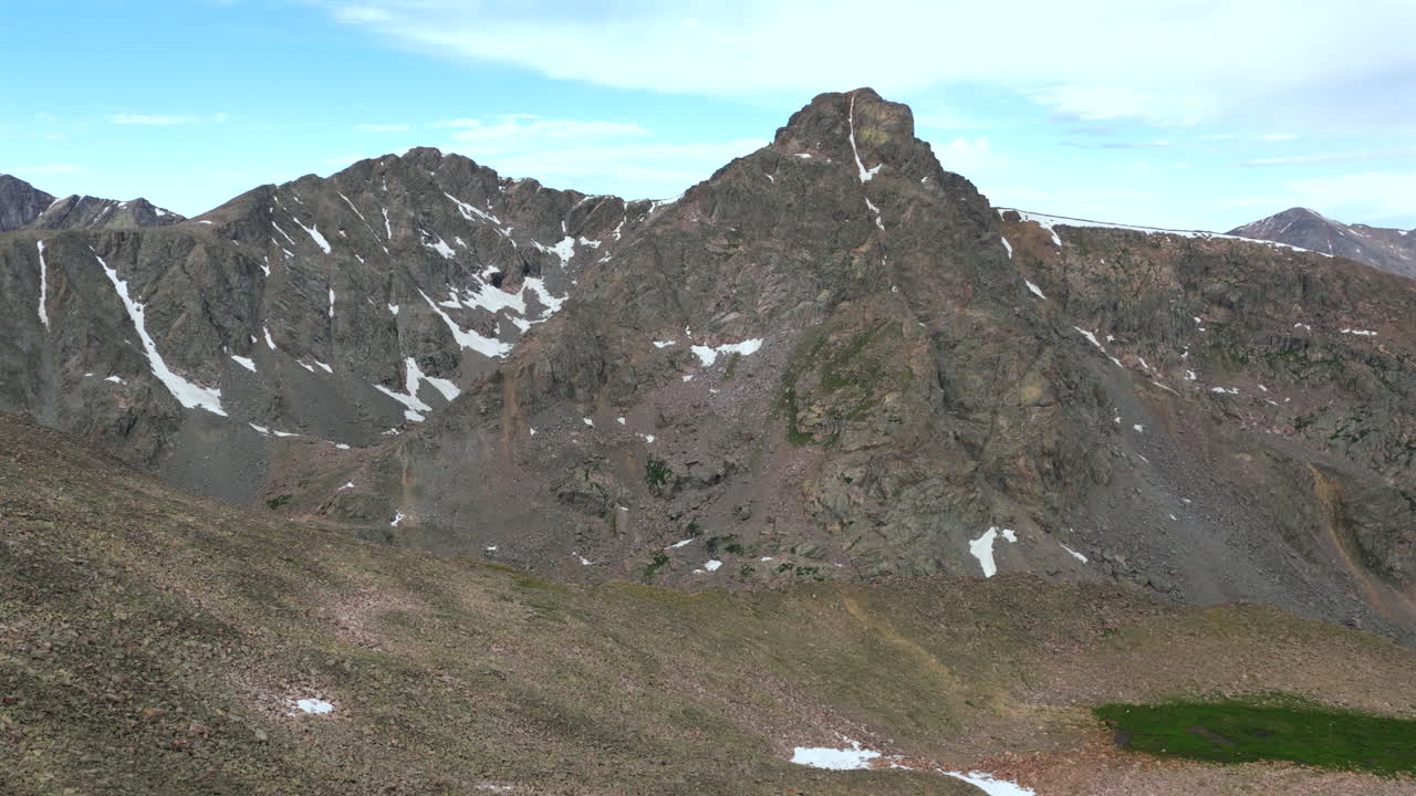 Mount of the Holy Cross 14er prominent peak wilderness landscape view aerial drone Colorado morning clouds North Mountain Shelter Halo Ridge Bowl alpine tundra snow melt Rocky Mountains forward pan up