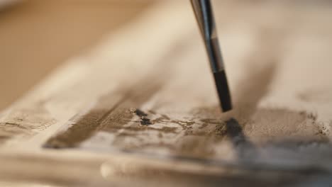 closeup-of-a-small-brush-making-little-paint-dots-on-white-paper