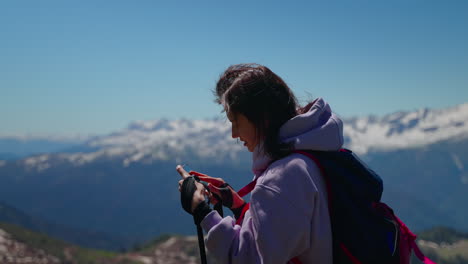 woman hiking in mountains with smartphone