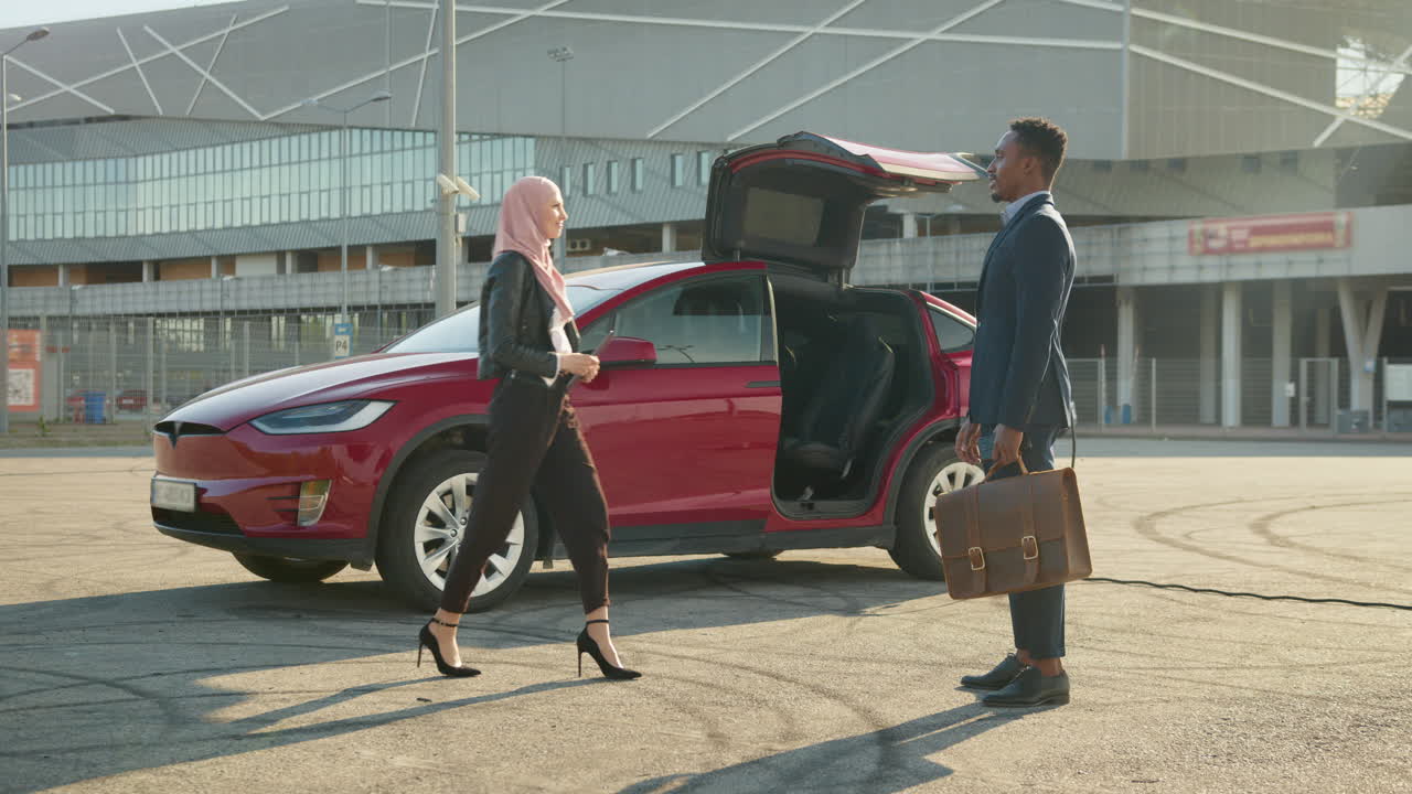 은 전기 자동차 근처 에서 이야기 하는 사업가 들