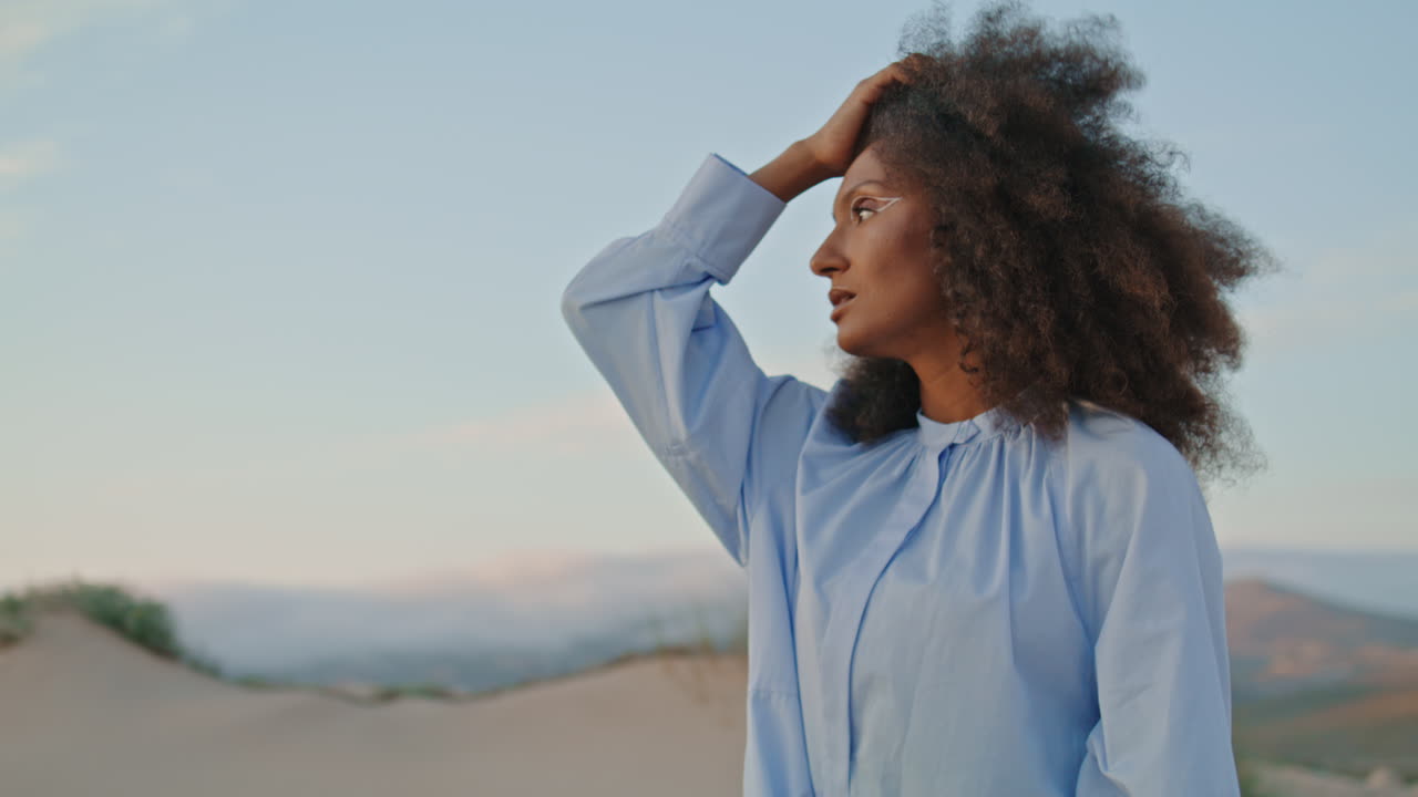 Girl model posing desert summer evening close up. Curly woman touching hairstyle