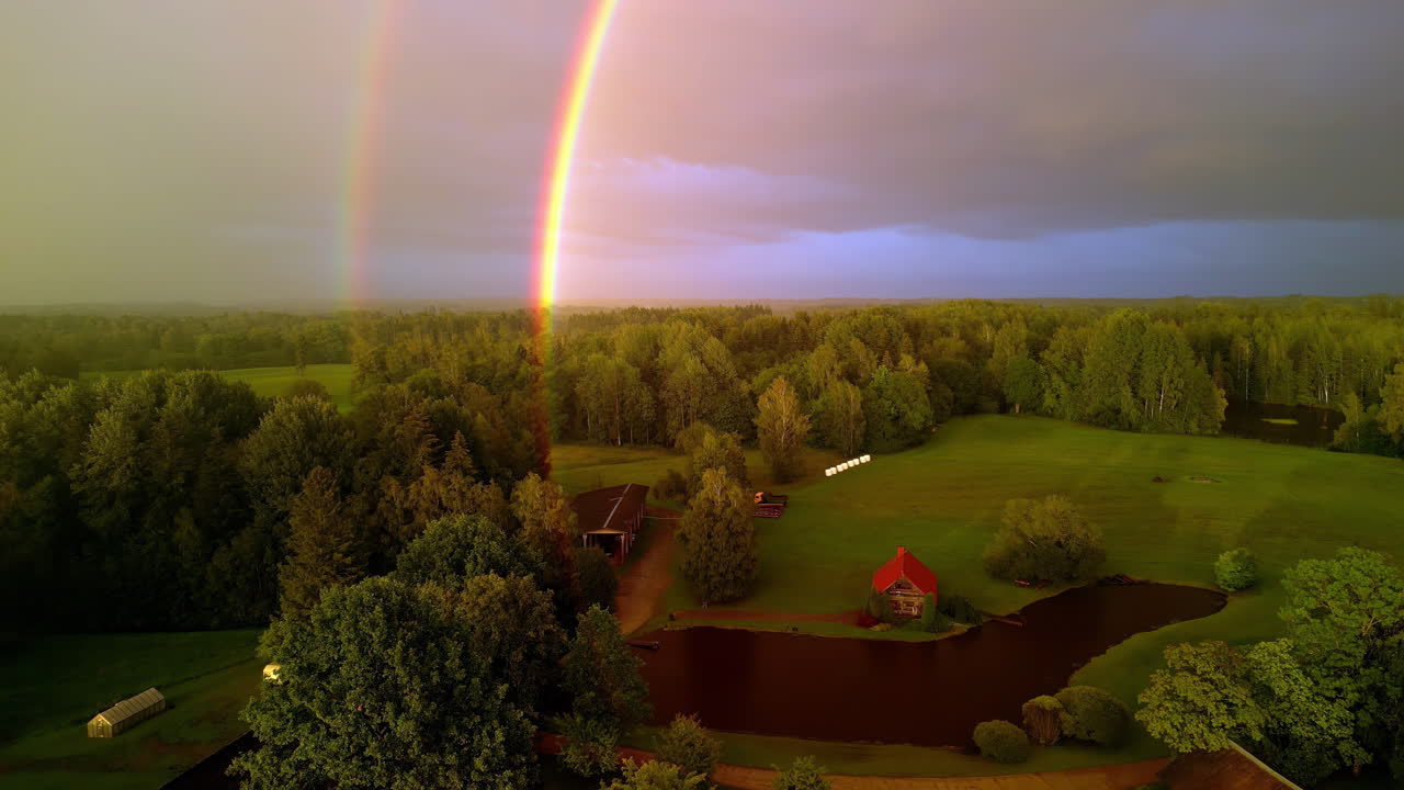 vista aérea de un doble arco iris en el campo en un día nublado