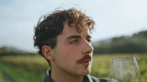 Sommelier-mixing-white-wine-in-goblet-standing-at-vineyard-sunny-day-close-up.