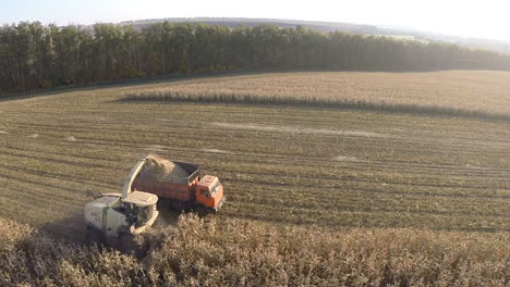 flying over combine and truck harvesting crops