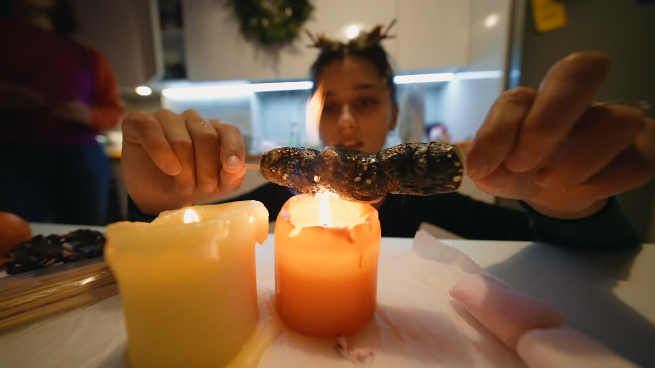 Woman toasting marshmallows on candles