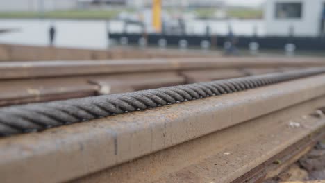 rusty iron chain pulling over a rail in the harbour