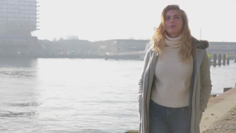 happy young tourist woman explores a city along the pier