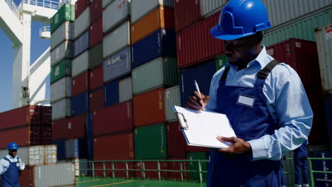 worker inspecting shipping containers on a cargo ship