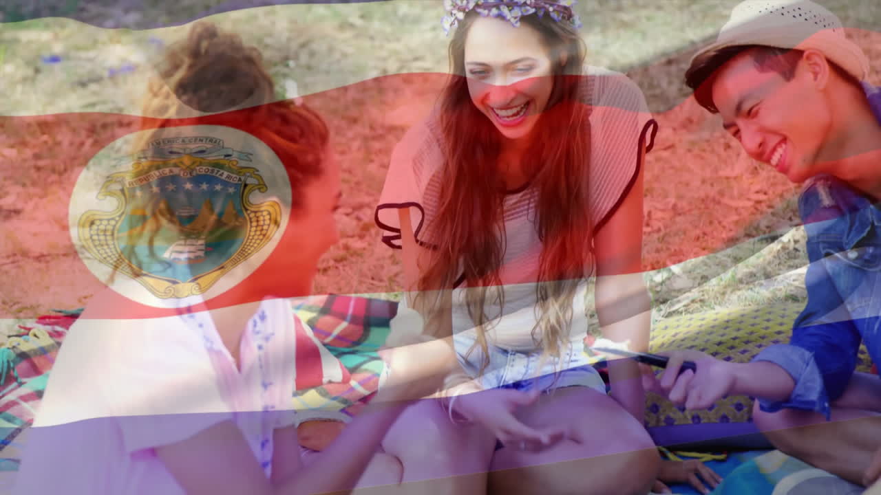 친구들이 담요 위에 앉아 웃고 대화하고, 코스타리카 발 애니메이션을 보고 있습니다.