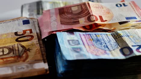 slow motion view of colorful euro bills turning on table, economic concept frame