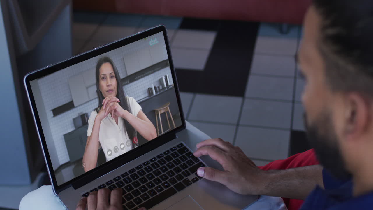 Middle eastern man having a video call with female colleague on laptop